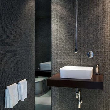 Modern bathroom with wood counter and glass mosaic walls