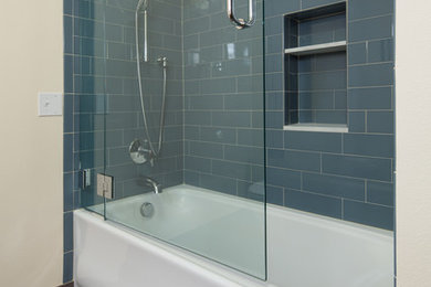 Foto de cuarto de baño minimalista grande con bañera empotrada, combinación de ducha y bañera, baldosas y/o azulejos azules, baldosas y/o azulejos de cemento, paredes amarillas y suelo de baldosas de cerámica