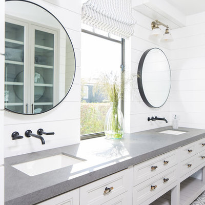 Inspiration for a coastal gray floor bathroom remodel in Orange County with recessed-panel cabinets, white cabinets, white walls, an undermount sink and gray countertops