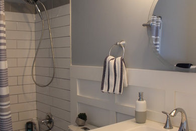 Example of a mid-sized beach style master white tile and subway tile porcelain tile and white floor bathroom design in Calgary with raised-panel cabinets, gray cabinets, a two-piece toilet, blue walls, an integrated sink, solid surface countertops and white countertops