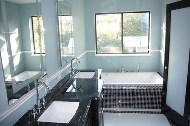 Example of a mid-sized minimalist master white tile and glass tile mosaic tile floor bathroom design in Other with a two-piece toilet, blue walls, an undermount sink and granite countertops