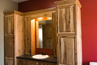 Foto de cuarto de baño principal de estilo americano de tamaño medio con armarios estilo shaker, puertas de armario de madera oscura, bañera exenta, sanitario de una pieza, paredes rojas y encimera de laminado
