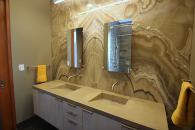 サンフランシスコにあるお手頃価格の中くらいなモダンスタイルのおしゃれなマスターバスルーム (フラットパネル扉のキャビネット、白いキャビネット、置き型浴槽、コーナー設置型シャワー、一体型トイレ	、ベージュのタイル、石スラブタイル、ベージュの壁、一体型シンク、クオーツストーンの洗面台) の写真