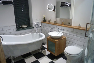 Cette photo montre une salle de bain tendance en bois brun de taille moyenne pour enfant avec un placard à porte vitrée, une baignoire indépendante, une douche d'angle, WC à poser, un carrelage blanc, des carreaux de céramique, un mur blanc, un sol en vinyl, une vasque et un plan de toilette en bois.