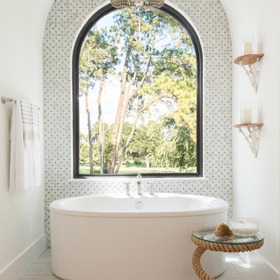 Freestanding bathtub - coastal gray floor freestanding bathtub idea in Houston with white walls