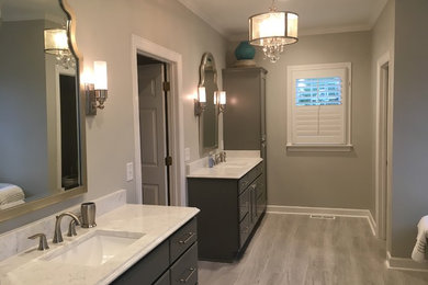 Photo of a medium sized classic ensuite bathroom in Nashville with flat-panel cabinets, grey cabinets, a freestanding bath, an alcove shower, white tiles, metro tiles, grey walls, porcelain flooring, a submerged sink, quartz worktops, grey floors, a hinged door and white worktops.