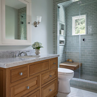 Alcove shower - mid-sized craftsman 3/4 green tile and subway tile porcelain tile and white floor alcove shower idea in San Francisco with shaker cabinets, medium tone wood cabinets, a two-piece toilet, green walls, an undermount sink, marble countertops and a hinged shower door