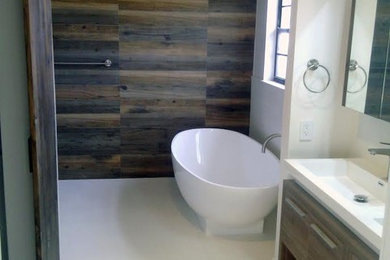 Aménagement d'une salle de bain craftsman en bois brun de taille moyenne avec un placard à porte plane, une baignoire indépendante, un lavabo intégré et un plan de toilette en surface solide.