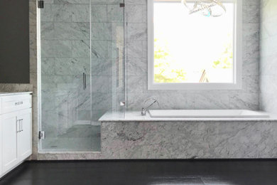 Example of a mid-sized minimalist master marble tile dark wood floor and brown floor drop-in bathtub design in Dallas with shaker cabinets, white cabinets, gray walls, an undermount sink and marble countertops