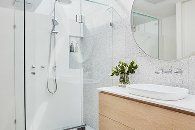 Стильный дизайн: ванная комната в стиле модернизм с плоскими фасадами, желтыми фасадами, угловым душем, серыми стенами, подвесной раковиной и душем с распашными дверями - последний тренд