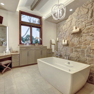 Modelo de cuarto de baño principal, de estilo de casa de campo, con armarios con paneles empotrados, puertas de armario beige, bañera exenta, paredes blancas, lavabo bajoencimera y suelo beige