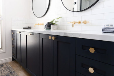 Mid-sized farmhouse 3/4 white tile and subway tile travertine floor, brown floor and double-sink bathroom photo in Phoenix with shaker cabinets, blue cabinets, a one-piece toilet, white walls, an undermount sink, quartz countertops, white countertops, a niche and a built-in vanity