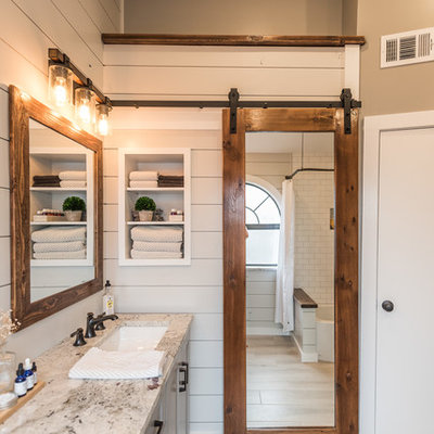 Bathroom - mid-sized cottage master gray tile and porcelain tile porcelain tile bathroom idea in Dallas with shaker cabinets, gray cabinets, a one-piece toilet, gray walls, an undermount sink and granite countertops
