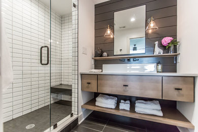 Mid-sized farmhouse 3/4 white tile and ceramic tile porcelain tile and black floor alcove shower photo in DC Metro with flat-panel cabinets, brown cabinets, a two-piece toilet, white walls, a vessel sink, quartz countertops, a hinged shower door and white countertops