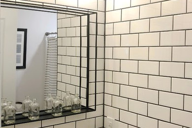 This is an example of a small country bathroom in Cleveland with shaker cabinets, black cabinets, a built-in bath, a shower/bath combination, a one-piece toilet, white tiles, metro tiles, an integrated sink, marble worktops, a shower curtain and white worktops.
