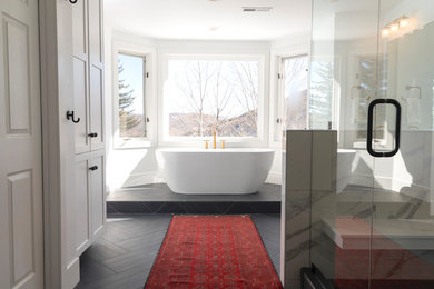 Inspiration for a large country master white tile and porcelain tile slate floor and black floor bathroom remodel in Salt Lake City with shaker cabinets, white cabinets, a two-piece toilet, white walls, an undermount sink, quartz countertops, a hinged shower door and white countertops