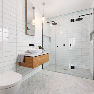 Foto di una stanza da bagno con doccia contemporanea con doccia doppia, WC sospeso, piastrelle bianche, piastrelle diamantate, pareti bianche, lavabo a bacinella, ante lisce, ante in legno scuro e porta doccia a battente