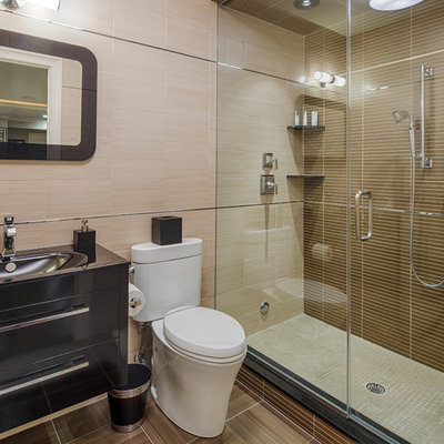 Inspiration for a mid-sized contemporary 3/4 brown tile and porcelain tile porcelain tile and brown floor alcove shower remodel in New York with an integrated sink, a two-piece toilet, flat-panel cabinets, black cabinets, solid surface countertops, a hinged shower door and black countertops