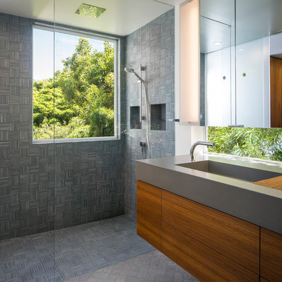Mid-sized minimalist master gray tile and porcelain tile porcelain tile walk-in shower photo in San Francisco with an integrated sink, flat-panel cabinets, medium tone wood cabinets, concrete countertops, a wall-mount toilet and white walls