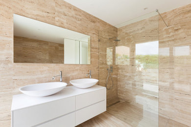 Design ideas for a large contemporary ensuite bathroom in San Diego with flat-panel cabinets, white cabinets, a walk-in shower, beige tiles, porcelain tiles, beige walls, porcelain flooring, a vessel sink, solid surface worktops, beige floors and an open shower.