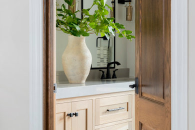 Idées déco pour une salle de bain moderne en bois clair avec un plan de toilette blanc et meuble double vasque.