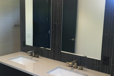 Example of a mid-sized minimalist master porcelain tile bathroom design in Other with flat-panel cabinets, black cabinets, an undermount sink and quartz countertops