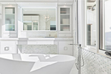Idéer för att renovera ett stort funkis vit vitt en-suite badrum, med släta luckor, vita skåp, ett fristående badkar, en dubbeldusch, en toalettstol med hel cisternkåpa, vit kakel, mosaik, vita väggar, klinkergolv i porslin, ett fristående handfat, bänkskiva i kvartsit, vitt golv och dusch med gångjärnsdörr