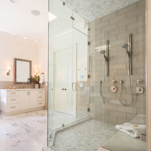 Immagine di una grande stanza da bagno padronale tradizionale con ante con bugna sagomata, ante bianche, vasca freestanding, doccia ad angolo, piastrelle grigie, piastrelle di vetro, pareti bianche, pavimento in marmo, lavabo sottopiano e top in marmo