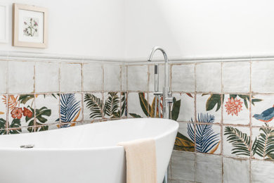 Inspiration for a mid-sized eclectic master multicolored tile and ceramic tile blue floor and double-sink freestanding bathtub remodel in Atlanta with flat-panel cabinets, medium tone wood cabinets, white walls, a drop-in sink, quartzite countertops, beige countertops and a built-in vanity