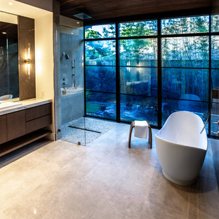 Exempel på ett mycket stort modernt vit vitt en-suite badrum, med släta luckor, skåp i ljust trä, ett fristående badkar, en kantlös dusch, en vägghängd toalettstol, grå kakel, stenhäll, grå väggar, klinkergolv i porslin, ett avlångt handfat, marmorbänkskiva, beiget golv och med dusch som är öppen