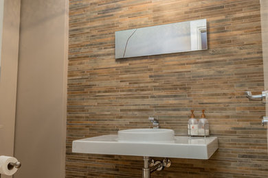 モントリオールにある低価格の小さなモダンスタイルのおしゃれなバスルーム (浴槽なし) (一体型トイレ	、モザイクタイル、グレーの壁、淡色無垢フローリング、壁付け型シンク) の写真