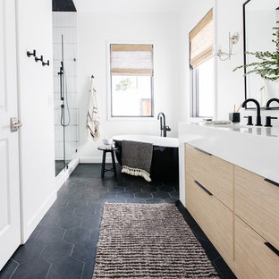 Foto di una stanza da bagno padronale scandinava di medie dimensioni con ante lisce, ante in legno chiaro, vasca freestanding, doccia alcova, pareti bianche, pavimento con piastrelle in ceramica, lavabo sottopiano, top in quarzite, pavimento nero, porta doccia a battente e top bianco