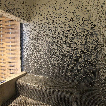 Modern sit in shower with custom recycled glass mosaic gradient walls