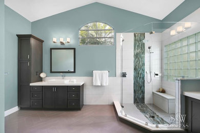 Inspiration for a large contemporary master gray tile and porcelain tile porcelain tile doorless shower remodel in Orlando with shaker cabinets, dark wood cabinets, a one-piece toilet, blue walls, a vessel sink and quartz countertops