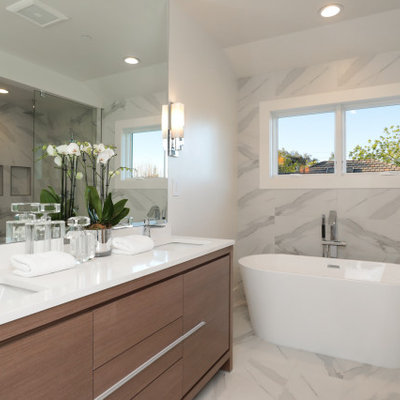 Example of a transitional master white tile white floor and double-sink bathroom design in San Francisco with flat-panel cabinets, medium tone wood cabinets, an undermount sink, white countertops and a freestanding vanity