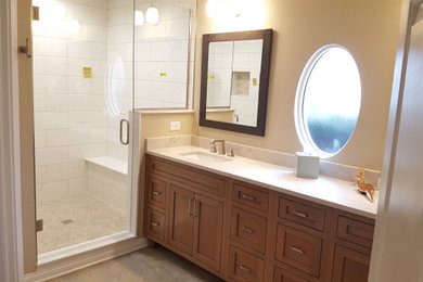 Mid-sized elegant master white tile and ceramic tile ceramic tile, black floor and double-sink bathroom photo in Indianapolis with flat-panel cabinets, medium tone wood cabinets, a two-piece toilet, beige walls, an undermount sink, quartz countertops, a hinged shower door, white countertops and a freestanding vanity