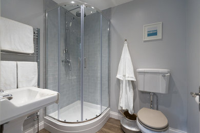Foto di una stanza da bagno con doccia tradizionale di medie dimensioni con doccia ad angolo, WC a due pezzi, piastrelle grigie, piastrelle in ceramica, pareti grigie, pavimento in linoleum e lavabo a colonna