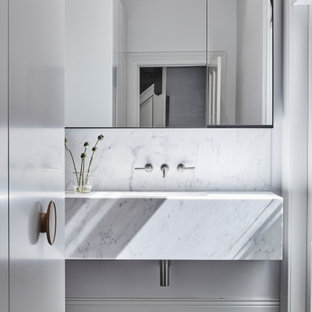 Design ideas for a modern bathroom in Melbourne with white cabinets, white tile, white walls, an undermount sink, a single vanity, a floating vanity, marble, dark hardwood floors, marble benchtops, white benchtops and brown floor.