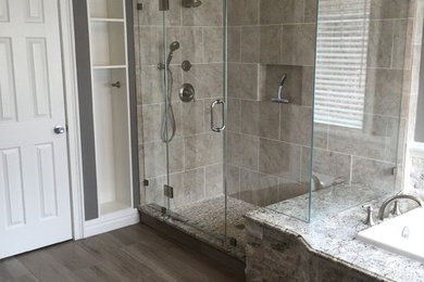Large tuscan master beige tile and stone tile porcelain tile bathroom photo in New York with a two-piece toilet, gray walls, an undermount sink, granite countertops, raised-panel cabinets and dark wood cabinets