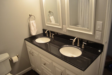 Photo of a medium sized modern family bathroom in Philadelphia with a submerged sink, raised-panel cabinets, white cabinets, granite worktops, a two-piece toilet, grey walls and lino flooring.