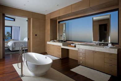 Inspiration for a medium sized contemporary ensuite bathroom in Los Angeles with flat-panel cabinets, medium wood cabinets, a freestanding bath, a submerged sink and dark hardwood flooring.