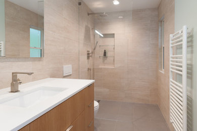 Example of a minimalist beige tile and ceramic tile porcelain tile walk-in shower design in San Francisco with a wall-mount sink, flat-panel cabinets, light wood cabinets, quartz countertops and beige walls