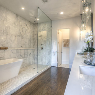 Inspiration for a large transitional master bathroom in Houston with an undermount sink, a freestanding tub, an open shower, dark hardwood floors, an open shower, furniture-like cabinets, a two-piece toilet, white tile, marble, white walls, engineered quartz benchtops, brown floor and white benchtops.