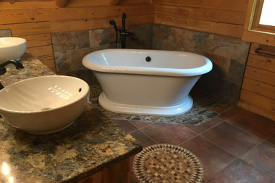 Mid-sized mountain style master stone tile mosaic tile floor, double-sink and wood wall freestanding bathtub photo in Denver with a vessel sink, quartzite countertops, multicolored countertops and a built-in vanity