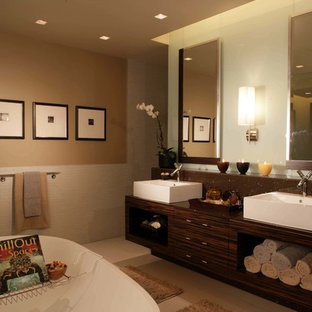 Mittelgroßes Asiatisches Badezimmer En Suite mit flächenbündigen Schrankfronten, dunklen Holzschränken, freistehender Badewanne, offener Dusche, Toilette mit Aufsatzspülkasten, braunen Fliesen, Steinplatten, beiger Wandfarbe, Keramikboden, Sockelwaschbecken, Mineralwerkstoff-Waschtisch, beigem Boden und offener Dusche in Kansas City