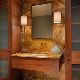 This is an example of a contemporary bathroom in Miami with an undermount sink, glass-front cabinets, medium wood cabinets, brown tile, stone slab and medium hardwood floors.