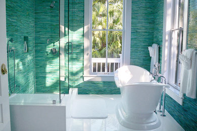 ニューヨークにあるラグジュアリーな中くらいなトロピカルスタイルのおしゃれな浴室 (置き型浴槽、コーナー設置型シャワー、青い壁) の写真