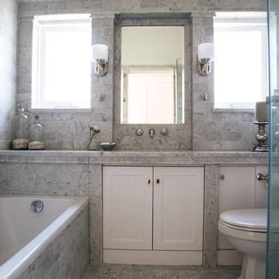 Drop-in bathtub - mid-sized traditional gray tile and marble tile marble floor and gray floor drop-in bathtub idea in Sydney with gray walls, a hinged shower door, gray countertops, a two-piece toilet, an undermount sink, shaker cabinets and marble countertops