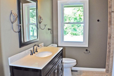 Example of a mid-sized classic beige tile and ceramic tile ceramic tile bathroom design in Minneapolis with an integrated sink, furniture-like cabinets, dark wood cabinets, granite countertops and brown walls