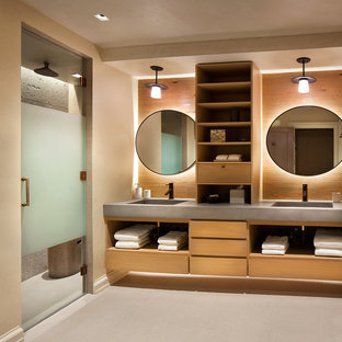 Modelo de cuarto de baño rústico con armarios con paneles lisos, puertas de armario de madera oscura, ducha empotrada, paredes beige, lavabo integrado, encimera de cemento y ducha con puerta con bisagras